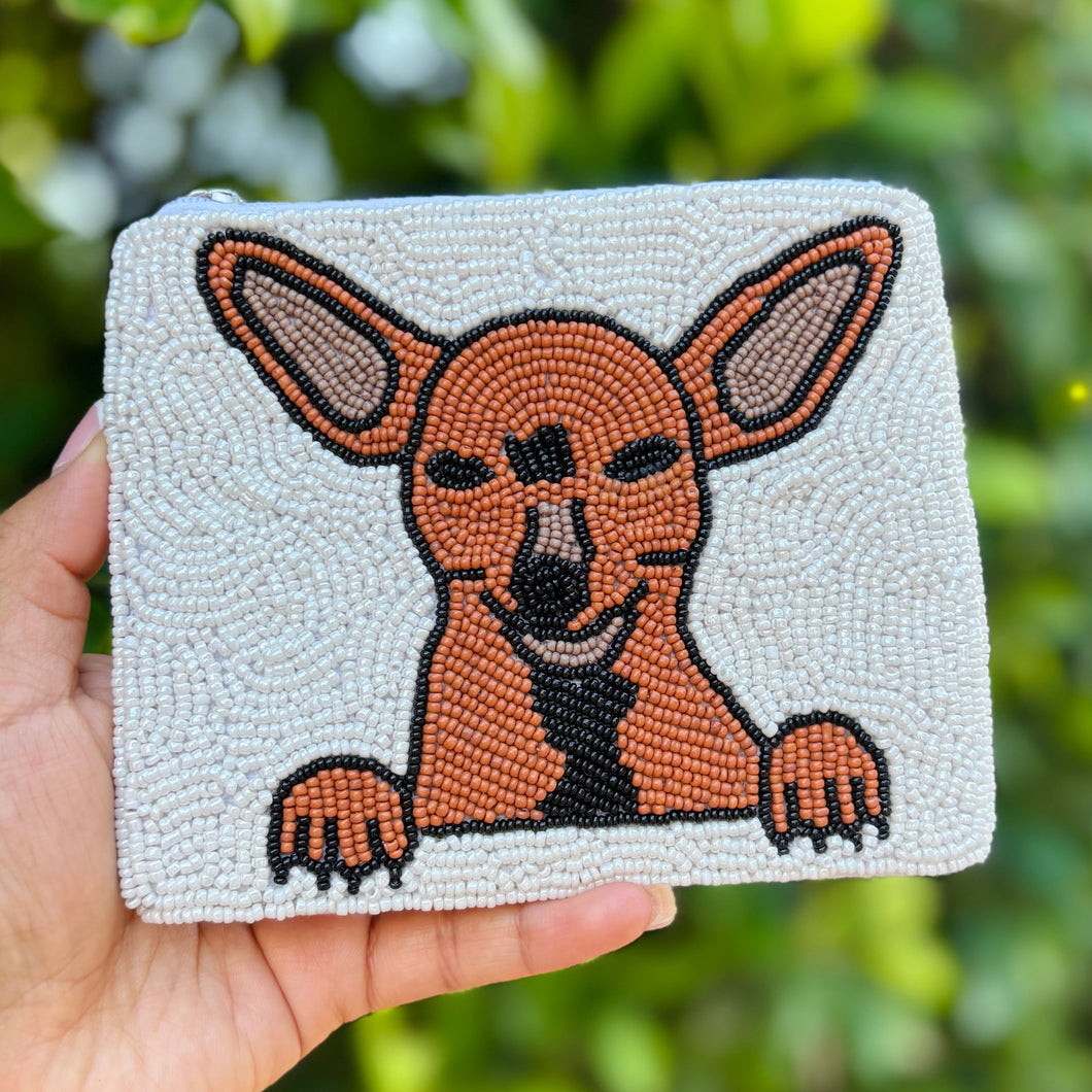 A beaded pouch featuring a Chihuahua design. The tan and black dog with large ears and paws pops against a white beaded background, evoking playful charm.