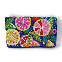 Load image into Gallery viewer, A rectangular clutch purse featuring a vibrant, multicolored beaded design of citrus slices (lemons, limes, grapefruits) and green leaves on a dark navy blue background, shown against a plain white background.