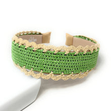 Load image into Gallery viewer, A woven green and beige lace cuff bracelet displayed on a white surface against a white background.