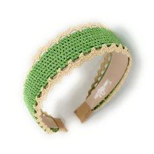 Load image into Gallery viewer, A handmade crochet headband in light green with a beige scalloped lace trim and a beige adjustable metal clasp, shown on a white background.