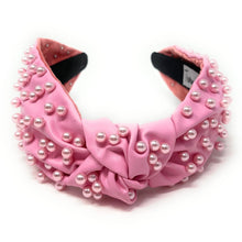 Load image into Gallery viewer, Elegant pink statement headband with pearl accents styled for a glamorous outfit, adding texture and sophistication to the look.