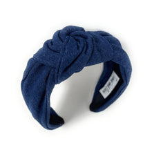 Load image into Gallery viewer, A dark blue denim fabric headband with a centered knot design sits on a white background. The soft texture and simple style convey a casual, elegant tone.