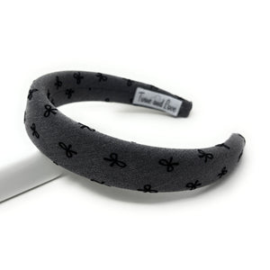 Gray headband with black bow pattern on a white background