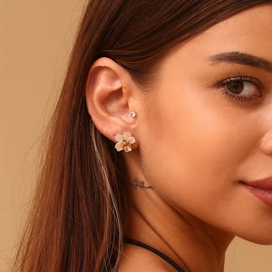 Delicate flower-shaped earrings with white petals and gold center on a white background. They emit an elegant, sophisticated tone.