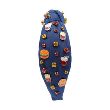 Load image into Gallery viewer, A blue denim headband with a knot design, decorated with red, gold, and clear rhinestones and small enamel fast-food-themed pins, including fries and sodas.