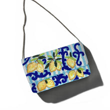 Load image into Gallery viewer, A small rectangular shoulder bag with a blue and white patterned body featuring yellow lemons and green leaves, suspended from a thin silver chain against a white background.
