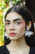 Load image into Gallery viewer, Elegant portrait featuring sparkling silver statement earrings with crystal embellishments, paired with a sophisticated black dress.