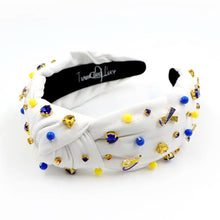 Load image into Gallery viewer, White padded headband with a twisted design, adorned with vibrant blue, yellow gemstones and down syndrome awareness charms. 