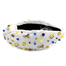 Load image into Gallery viewer, White padded headband with a twisted design, adorned with vibrant blue, yellow gemstones and down syndrome awareness charms. 