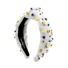Load image into Gallery viewer, White padded headband with a twisted design, adorned with vibrant blue, yellow gemstones and down syndrome awareness charms. 