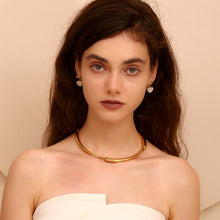 Load image into Gallery viewer, Woman wearing a gold necklace and heart gold plated earrings against a beige background