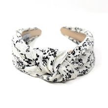 Load image into Gallery viewer, Elegant black floral print headband with a padded twisted silhouette and ivory base.