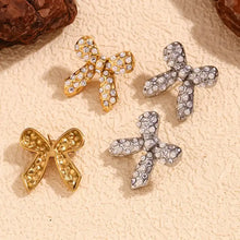 Load image into Gallery viewer, Bow-shaped earrings with rhinestones on a textured surface