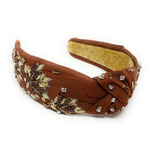 Brown headband with decorative elements on a white background
