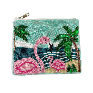 A beaded tropical pouch featuring pink flamingos, palm trees, and waves against a turquoise sky. The design is vibrant and playful, with a beachy vibe.