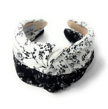 Load image into Gallery viewer, Two floral twist headbands in black and white fabric with soft padded silhouettes.