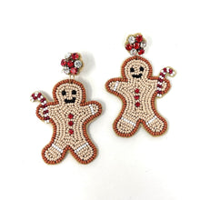 Load image into Gallery viewer, Beaded gingerbread man earrings with smiling faces and candy cane arms. Red and white beads form buttons, with red and clear rhinestone studs. Festive and playful.