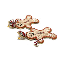 Load image into Gallery viewer, Beaded gingerbread man earrings with smiling faces and candy cane arms. Red and white beads form buttons, with red and clear rhinestone studs. Festive and playful.