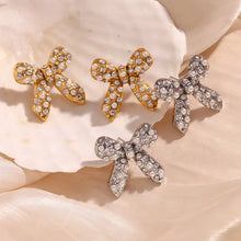 Load image into Gallery viewer, Bow-shaped earrings with rhinestones on a textured surface