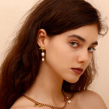 Load image into Gallery viewer, Gold starfish earrings with dangling white pearls on a white background. The design exudes a nautical, elegant, and summery vibe.
