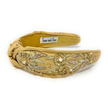 Load image into Gallery viewer, Golden padded headband adorned with intricate floral embroidery and pearl accents, exuding elegance and sophistication against a plain backdrop.