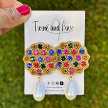 Load image into Gallery viewer, Gold earrings with a scalloped edge, featuring blue, red, green, and purple gemstones. Each earring has a dangling white teardrop pearl, exuding elegance.
