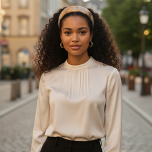 Load image into Gallery viewer, Woman wearing a beige blouse and black pants standing on a street.