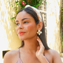 Load image into Gallery viewer, White flower statement earrings with gold trim and pearl-inspired center detail worn by a model.