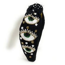 Load image into Gallery viewer, Fashion-forward black knot headband embellished with green and white beaded eye designs and sparkling details.