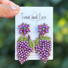 Load image into Gallery viewer, Purple grape cluster statement earrings featuring pearl beads, sparkling crystals, green beaded leaves, and floral stud tops. Handmade lightweight earrings by Twine and Love, perfect for vineyard events, wine lovers, and fall styling.