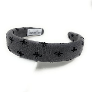 Gray headband with black bow pattern on a white background