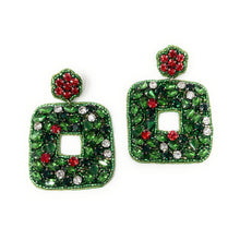 Load image into Gallery viewer, Dangling earrings feature vibrant green gemstones shaped like leaves with a red circular top. A small cluster of white stones accent the bottom. Festive and elegant.