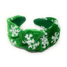 Load image into Gallery viewer, Green velvet headband adorned with white snowflake patterns. The texture is soft and plush, giving a festive, cheerful vibe against a plain white background.