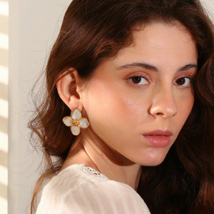 Close-up of a woman wearing a floral earring with a neutral background