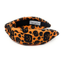Load image into Gallery viewer, Orange knotted headband with black Halloween-themed prints, featuring pumpkins and cats. The design is playful, capturing a festive Halloween vibe.
