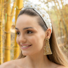 Load image into Gallery viewer, A fashionable woman wearing a decorative headband and elegant earrings in a natural outdoor setting.