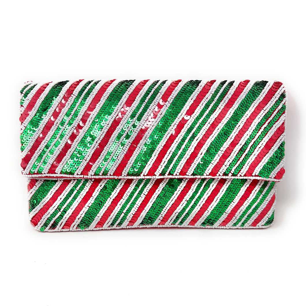 A festive clutch purse adorned with diagonal red, green, and white sequin stripes, creating a vibrant, shimmering pattern that evokes holiday cheer.