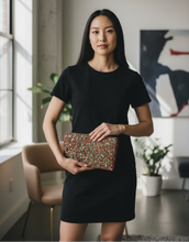 Load image into Gallery viewer, Woman holding a sequined clutch in a modern indoor setting