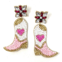 Load image into Gallery viewer, Model showcasing handcrafted cowboy boot earrings with pink accents and a pearl-adorned pink headband, creating a chic western look.