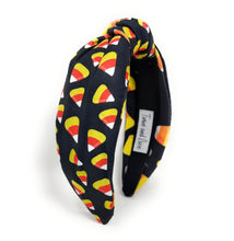 Load image into Gallery viewer, A black headband with colorful candy corn print, featuring white, orange, and yellow. Fun, Halloween-themed accessory.