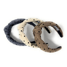 Load image into Gallery viewer, Three fabric headbands with black polka dots are arranged in a triangular pattern. They are beige, tan, and charcoal blue, each with a knotted design, conveying a casual, stylish tone.