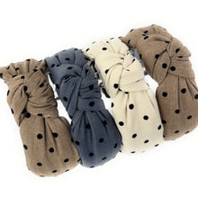 Load image into Gallery viewer, four fabric headbands with black polka dots are arranged in a triangular pattern. They are beige, tan, and charcoal blue, each with a knotted design, conveying a casual, stylish tone.