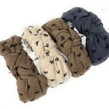 Load image into Gallery viewer, Set of five scrunchies in beige, brown, and gray with black bow patterns on a white background.