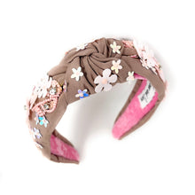 Load image into Gallery viewer, light Brown headband with pink interior, adorned with colorful floral applique and beading. The vibe is playful and feminine, showcasing detailed craftsmanship.