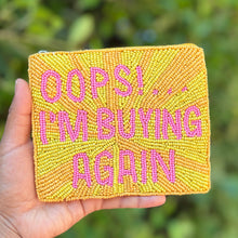 Load image into Gallery viewer, A hand holds a square yellow beaded patch with pink text that reads 'OOPS! I'M BUYING AGAIN".