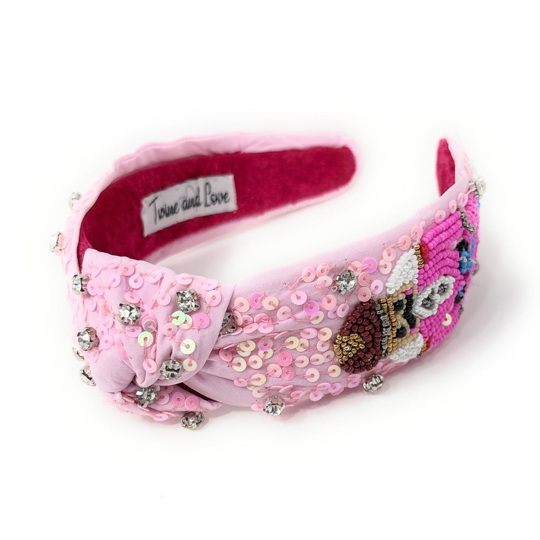 Pink nutcracker knot headband adorned with intricate beadwork, sequins, and rhinestones.