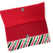 Load image into Gallery viewer, A festive clutch purse adorned with diagonal red, green, and white sequin stripes, creating a vibrant, shimmering pattern that evokes holiday cheer.