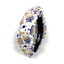 Load image into Gallery viewer, A fabric headband with a white background and a printed pattern of blue and gold menorahs and stars shown on a clean white background.