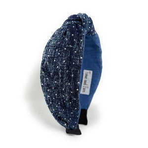 Blue denim headband with a knotted design, adorned with small rhinestones. The fabric texture adds a casual yet chic touch.