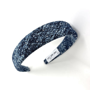 Dark blue denim headband with a textured pattern and rhinestones. The headband has a tag and lies on a white background.